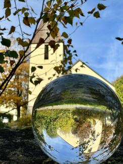 Matthäuskirche Bad Kötzting mit einer Glaskugel im Vordergrund, in der sich die Kirche spiegelt