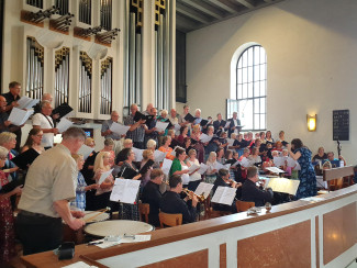 Chor und Orchester spielen festliche Musik auf der Orgelempore